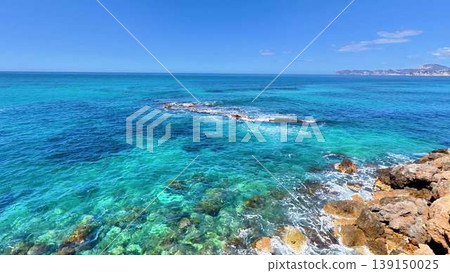 Aerial video shows serene turquoise ocean and rocky formations 139150025