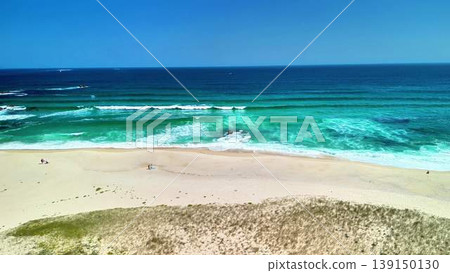 Experience a breathtaking coastal view showcasing rolling waves and a pristine sandy beach Experience a breathtaking coastal view showcasing rolling waves and a pristine sandy beach 139150130