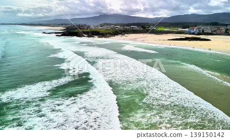 A breathtaking aerial view showcasing the scenic beauty of ocean waves and a picturesque beachfront A breathtaking aerial view showcasing the scenic beauty of ocean waves and a picturesque beachfront 139150142