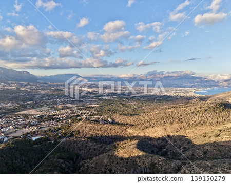 Sunshine illuminates hillside cityscape, Warm daylight highlights rolling terrain and distant coastlines 139150279