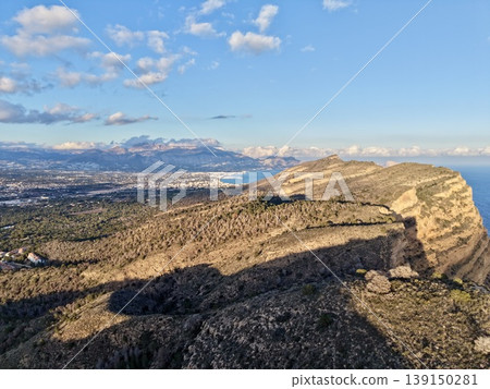 Scenic coastal panorama, Vivid landscape displays majestic cliffs and shimmering ocean under cloudy sky Scenic coastal panorama, Vivid landscape displays majestic cliffs and shimmering ocean under cloudy sky 139150281