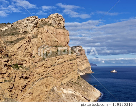 Serene ocean vista, Scenic shoreline view showing ship on serene waters beneath scattered clouds 139150316