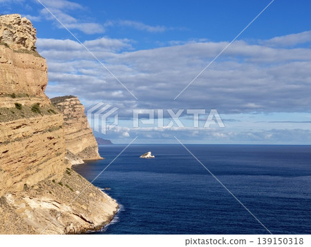 Serene shoreline with peaceful horizon, Idyllic headland view over tranquil waters and distant boats 139150318