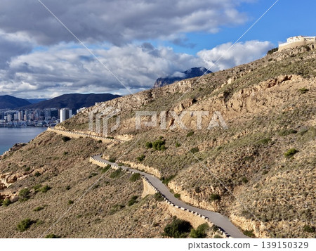 Dramatic sky over craggy cliffs, Foreboding atmosphere with contrasting shadows over rough terrain 139150329