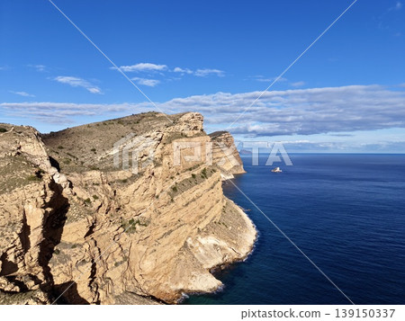 Alone boat by vast sea, Isolated high point overlooking open water and lone vessel under clear sky Alone boat by vast sea, Isolated high point overlooking open water and lone vessel under clear sky 139150337