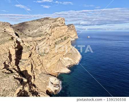 Sunlit cliffs and quiet sea, Serene coastal landscape with sunny rocks and tranquil ocean view 139150338