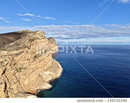 Vast maritime landscape, Enormous ocean view extending to infinity from jagged cliff under clear sky 139150340