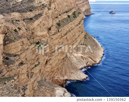 Imposing rock face beside azure sea offering breathtaking vistas and photographic opportunities 139150362