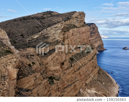 Rock face overview, Close examination of stratified weathered rocks with sparse plant life by sea Rock face overview, Close examination of stratified weathered rocks with sparse plant life by sea 139150363