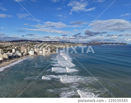 Intense coastal storm with urban backdrop, Majestic shoreline battle between waves and city skyline 139150385