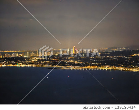 Calm coast at dusk scene. Serene twilight shoreline displaying luminous lights and still waters Calm coast at dusk scene. Serene twilight shoreline displaying luminous lights and still waters 139150434