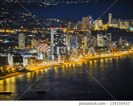 Bright skyline over tranquil waters. Vivid nighttime city views with vibrant waterfront illumination Bright skyline over tranquil waters. Vivid nighttime city views with vibrant waterfront illumination 139150437