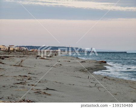 Sunset coast scenery. Twilight along suburban coast with exposed sands and peaceful community backdrop Sunset coast scenery. Twilight along suburban coast with exposed sands and peaceful community backdrop 139150480