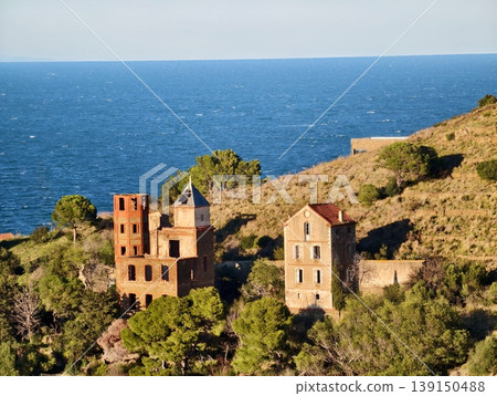 Silent relics of rural hillside abandonment. Weathered structures nestled on lonely coastal hillsides 139150488