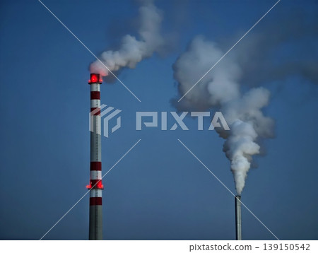 Factories emit pollution. Factory chimneys send dark smoke over open horizon during operation 139150542