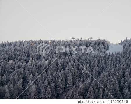 Winter landscape featuring icy tree crowns. Azure sky over frosty evergreen forest with haze Winter landscape featuring icy tree crowns. Azure sky over frosty evergreen forest with haze 139150546