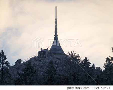 Morning mist over solitary tower. Peaceful early morning scene with silhouetted tower and pastel sky Morning mist over solitary tower. Peaceful early morning scene with silhouetted tower and pastel sky 139150574