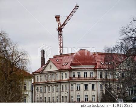 Old structure rebuilding. Historic edifice undergoing restoration amid urban industrial surroundings Old structure rebuilding. Historic edifice undergoing restoration amid urban industrial surroundings 139150585