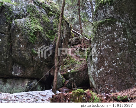 Peaceful winter scene. Calm outdoor bench nestled within snowdraped trees and rugged rocky outcrops Peaceful winter scene. Calm outdoor bench nestled within snowdraped trees and rugged rocky outcrops 139150597