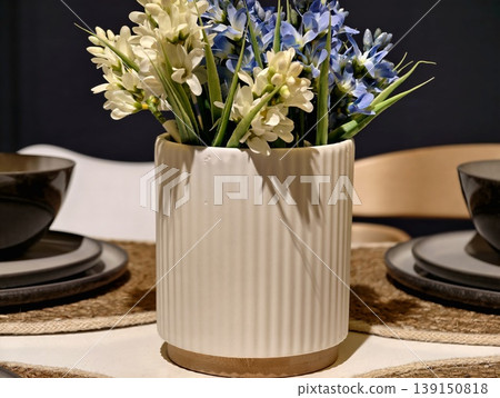 Sophisticated floral arrangement featuring hyacinths in white vase creating inviting dining ambiance Sophisticated floral arrangement featuring hyacinths in white vase creating inviting dining ambiance 139150818