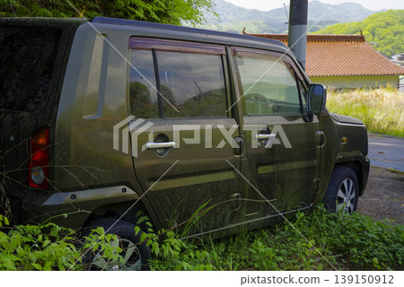 A vehicle that has been left abandoned for a long time, surrounded by vegetation. A vehicle that has been left abandoned for a long time, surrounded by vegetation. 139150912