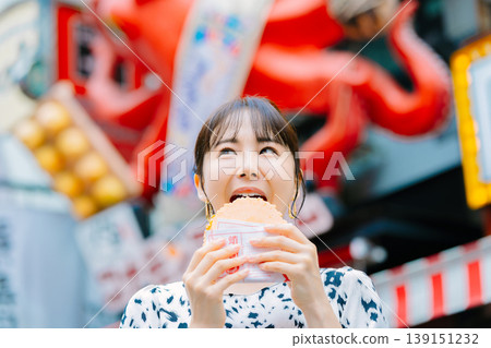 一位女士在大阪道頓堀吃著名的章魚線 139151232