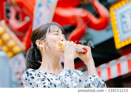 一位女士在大阪道頓堀吃著名的章魚線 139151233