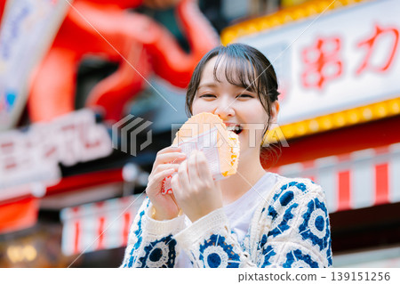一位女士在大阪道頓堀吃著名的章魚線 139151256