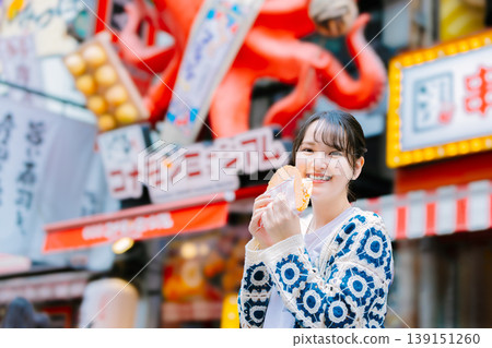 一位女士在大阪道頓堀吃著名的章魚線 139151260
