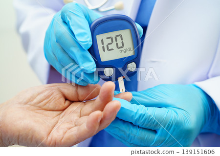 Asian doctor using digital glucose meter for check sample blood sugar level to treatment diabetes. 139151606