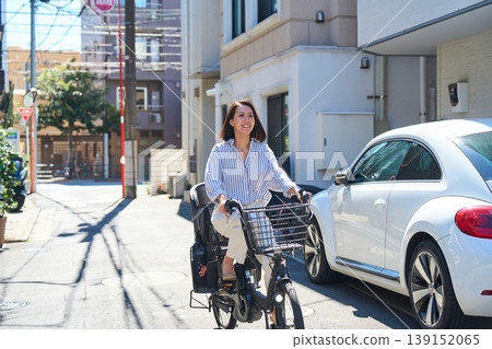 在陽光明媚的日子裡,一位日本女子微笑著騎著腳踏車。 在陽光明媚的日子裡,一位日本女子微笑著騎著腳踏車。 139152065