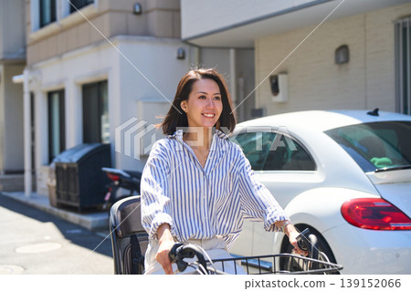A Japanese woman riding a bicycle with a smile on a sunny day. A Japanese woman riding a bicycle with a smile on a sunny day. 139152066