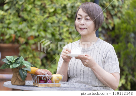 一位老婦人在露臺上喝咖啡 一位老婦人在露臺上喝咖啡 139152148
