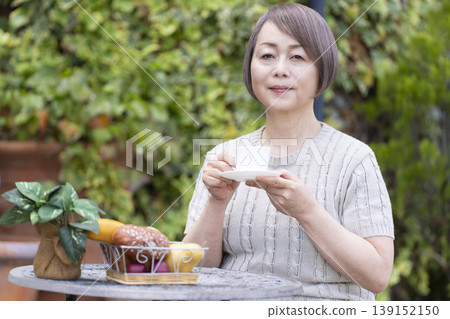 一位老婦人在露臺上喝咖啡 139152150