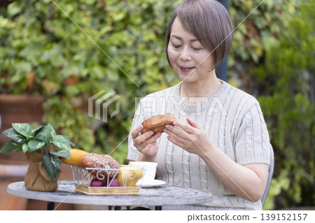 一位老婦人在露臺上喝咖啡 一位老婦人在露臺上喝咖啡 139152157