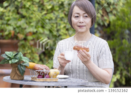 一位老婦人在露臺上喝咖啡 139152162