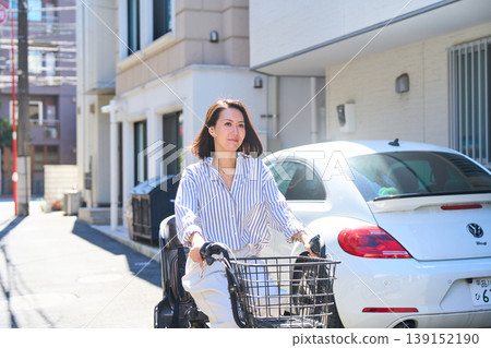 在陽光明媚的日子裡,一位日本女子微笑著騎著腳踏車。 在陽光明媚的日子裡,一位日本女子微笑著騎著腳踏車。 139152190