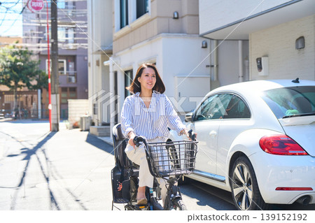在陽光明媚的日子裡，一位日本女子微笑著騎著腳踏車。 139152192