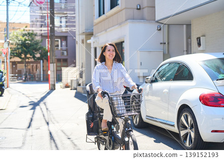 A Japanese woman riding a bicycle with a smile on a sunny day. A Japanese woman riding a bicycle with a smile on a sunny day. 139152193