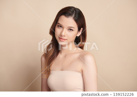 A beautiful young Asian woman with clean, fresh skin against a beige background. Skincare, facial treatment, cosmetology, beauty, and spa. An elegant portrait of an Asian woman. A beautiful young Asian woman with clean, fresh skin against a beige background. Skincare, facial treatment, cosmetology, beauty, and spa. An elegant portrait of an Asian woman. 139152226