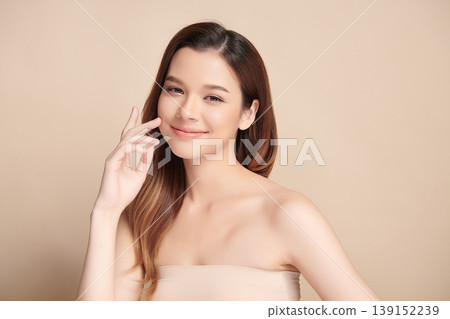 A beautiful young Asian woman with clean, fresh skin against a beige background. Skincare, facial treatment, cosmetology, beauty, and spa. An elegant portrait of an Asian woman. A beautiful young Asian woman with clean, fresh skin against a beige background. Skincare, facial treatment, cosmetology, beauty, and spa. An elegant portrait of an Asian woman. 139152239