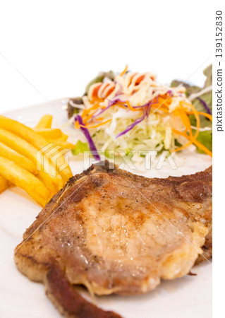 Top view of Steak pork chop with French Fries and Vegetable Salad put in the white dish, focus selective Top view of Steak pork chop with French Fries and Vegetable Salad put in the white dish, focus selective 139152830
