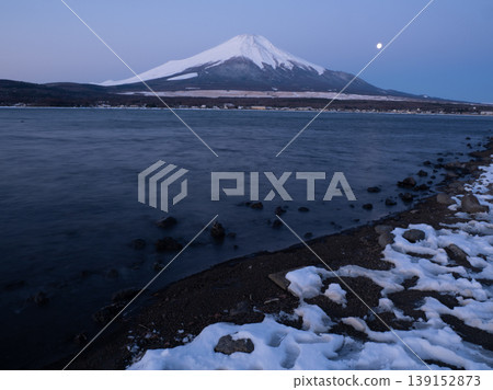 A winter view of Lake Yamanaka, with the silhouettes of a couple of diamond-shaped snow-capped peaks. A winter view of Lake Yamanaka, with the silhouettes of a couple of diamond-shaped snow-capped peaks. 139152873