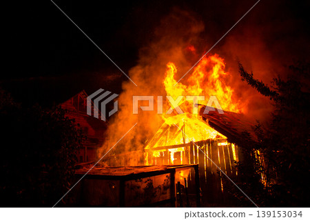 Wooden house or barn burning on fire at night. Wooden house or barn burning on fire at night. 139153034