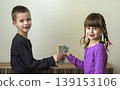 Two little children boy and girl playing with dollars money. 139153106