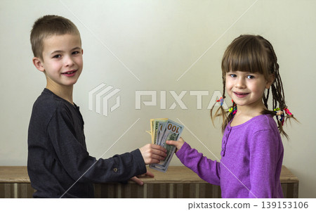 Two little children boy and girl playing with dollars money. 139153106