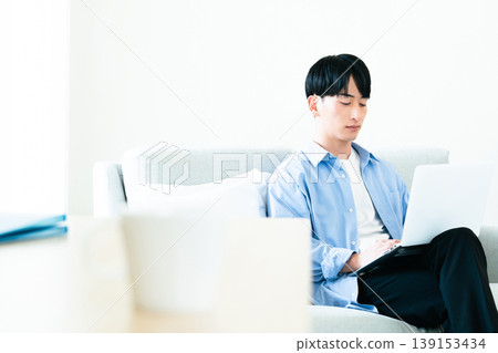 一個人在客廳裡使用個人電腦 139153434