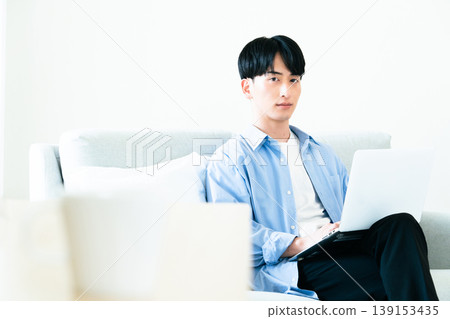 一個人在客廳裡使用個人電腦 139153435
