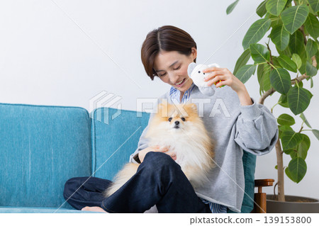 生活方式：一位女士在和她的狗以及玩具玩耍。 139153800