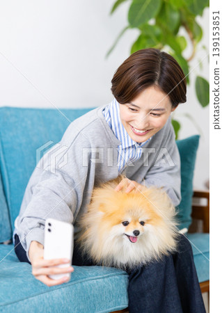 生活方式:一位女士用智慧型手機為她的狗拍照。 生活方式:一位女士用智慧型手機為她的狗拍照。 139153851